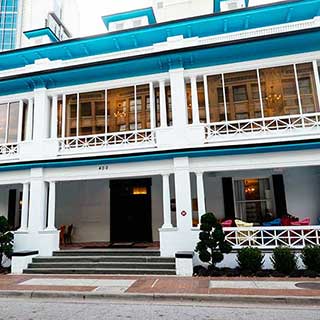 A white house with pillared porch and blue roof houses Sweet Pete’s in Jacksonville, Florida