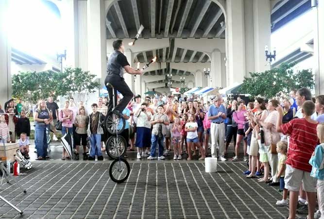 A unicycle rider juggles for a crowd at the Riverside Arts Market in Jacksonville, Florida