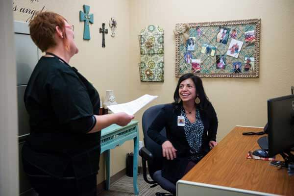 Two nursing professionals chat in an office in Lubbock, Texas