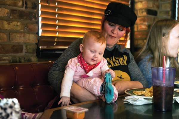 A woman holds a baby girl at a restaurant in Lubbock, Texas