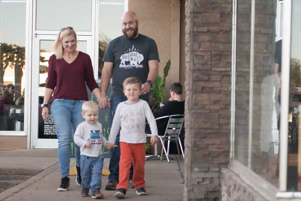 Parents walk hand-in-hand behind their young sons in Lubbock, TX