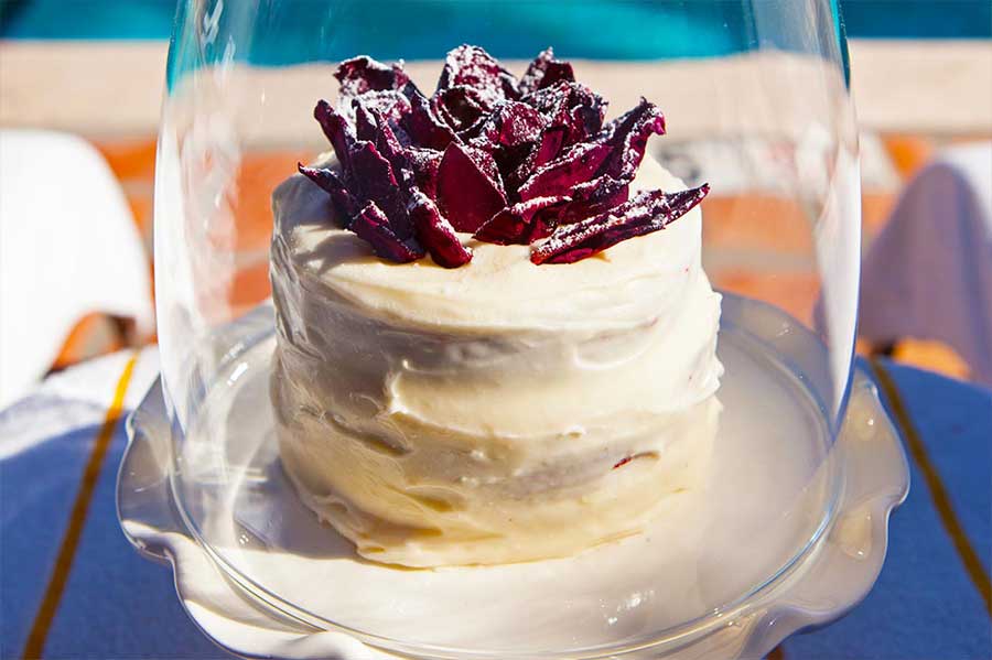 Artistic cake under a glass dome poolside at La Maison Hotel in Palm Springs, California