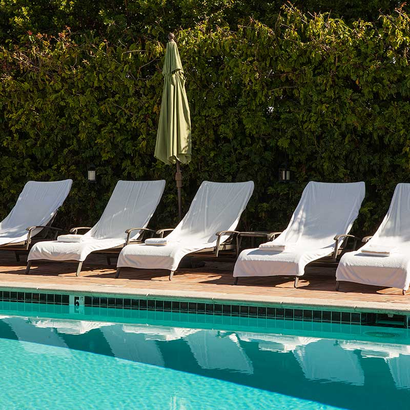 Chaise lounge chairs beside the pool at La Maison Hotel in Palm Springs, California