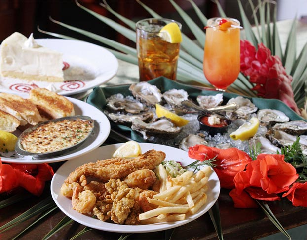 Plates of oysters, chicken tenders, French fries and drinks on a table in Carolina Beach, North Carolina