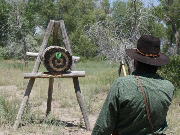 A man with a hatchet aims at a target in Wind River Country, Wyoming