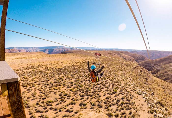 骑大峡谷Zipline的妇女。