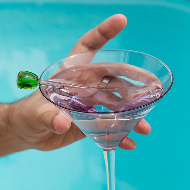 Cocktail with swizzle stick in hand