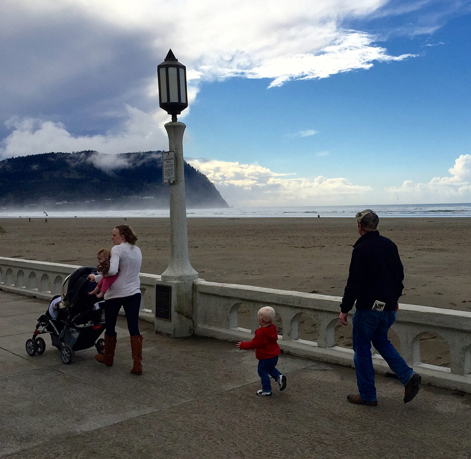 Family with young kids walking along the promenade in Seaside, Oregon