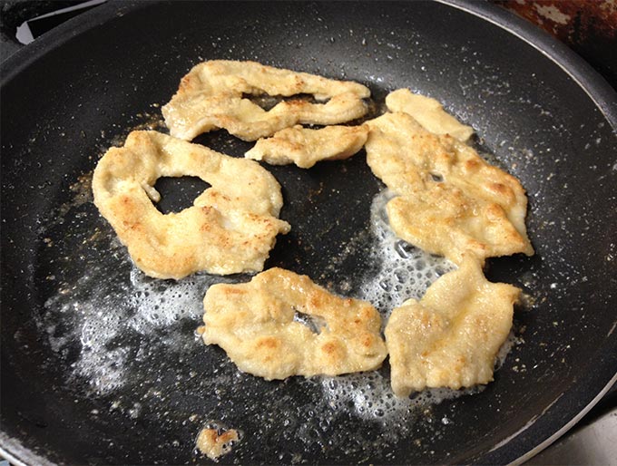 Razor clams from Seaside, Oregon being fried in a pan.