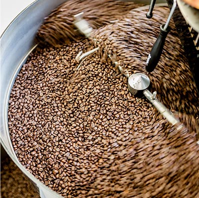 Freshly roasted Café Femenino coffee beans are mixed in a roasting machine at Snake River Roasting Co. in Jackson, WY