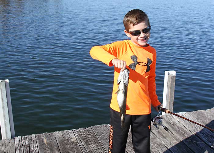 A young boy catches a fish with his rod and reel at Table Rock Lake, Missouri