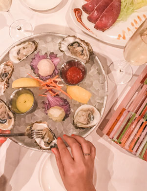 A photo of a dish of oysters served on ice with dipping sauces at Bern’s Steak House in Tampa Bay, Florida