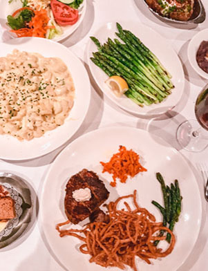 White dishes of food on a white tablecloth at Bern’s Steak House in Tampa Bay, Florida