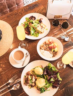 White plates of food on a brown wooden table at The Epicurean in Tampa Bay, Florida