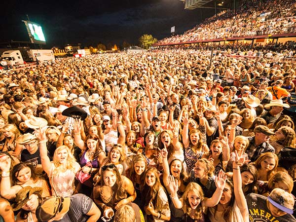 A crowd cheers at a Frontier Nights concert during the Cheyenne Frontier Days Rodeo in Cheyenne, WY