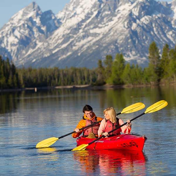 A man and a woman kayak on Jackson Lake in Grand Teton National Park in Wyoming
