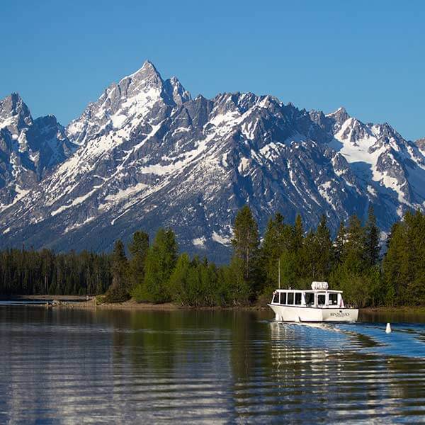A scenic cruise boat passes in front of Mount Moran on Jackson Lake in Grand Teton National Park in Moran, Wyoming