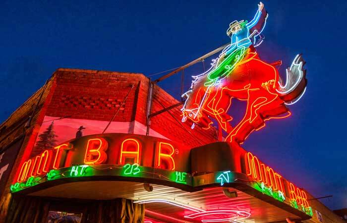 A neon sign of a cowboy riding a bucking bronco at Mint Bar in Sheridan, Wyoming