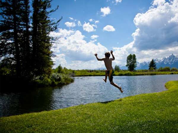 A child jumps into a lake during a family vacation at a dude ranch in Wyoming