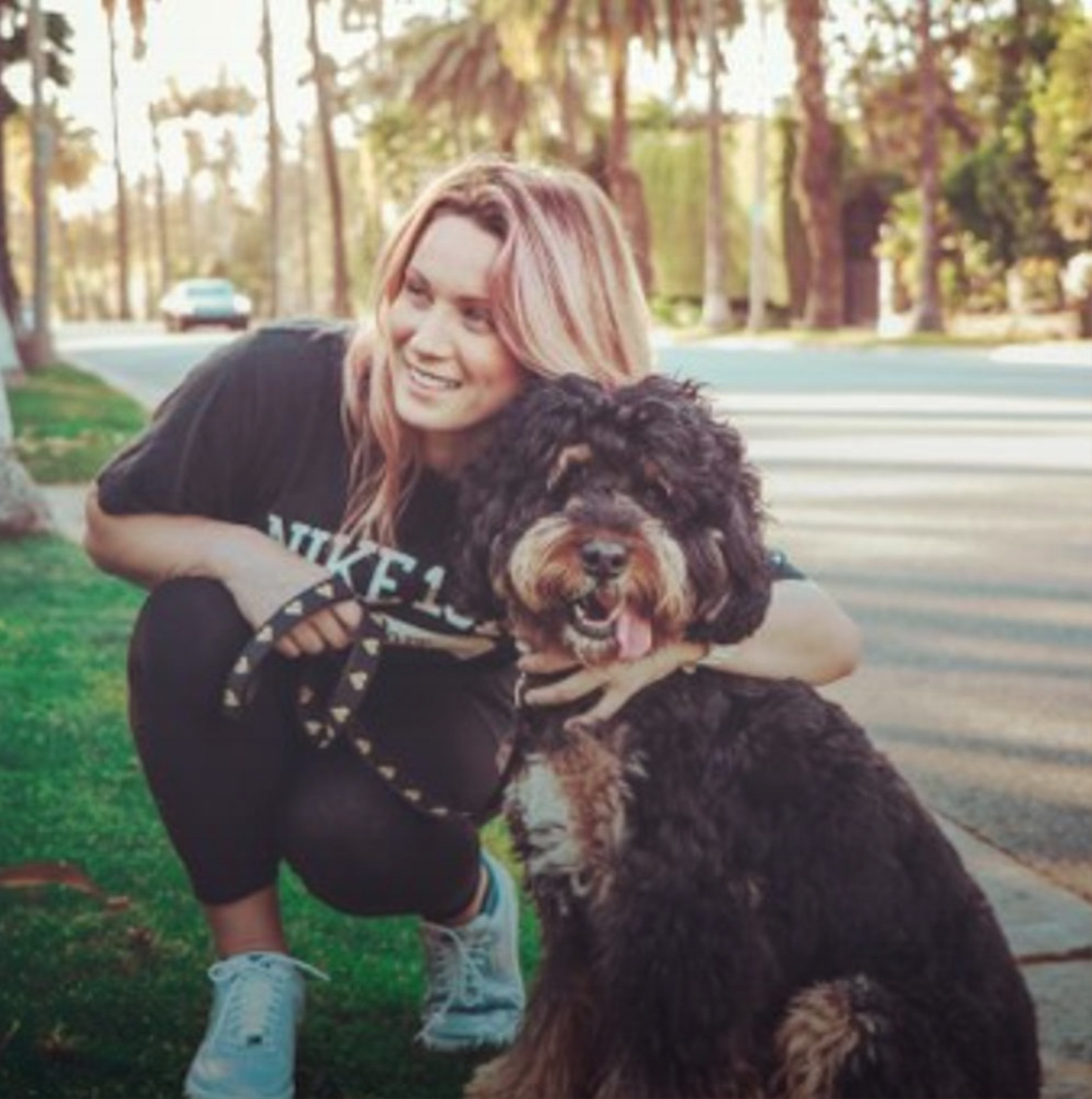 A woman hugs her labradoodle in Beverly Hills, CA. Instagram photo by @laraclear.