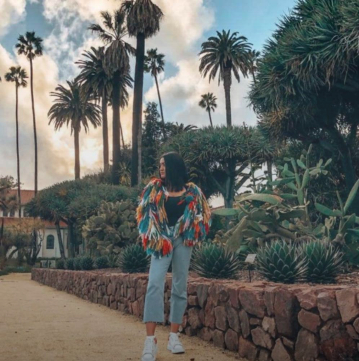 A woman with a chic colorful jacket stands in the Beverly Gardens Park Cactus Garden in Beverly Hills, CA. Instagram photo by @jazminilariadrina