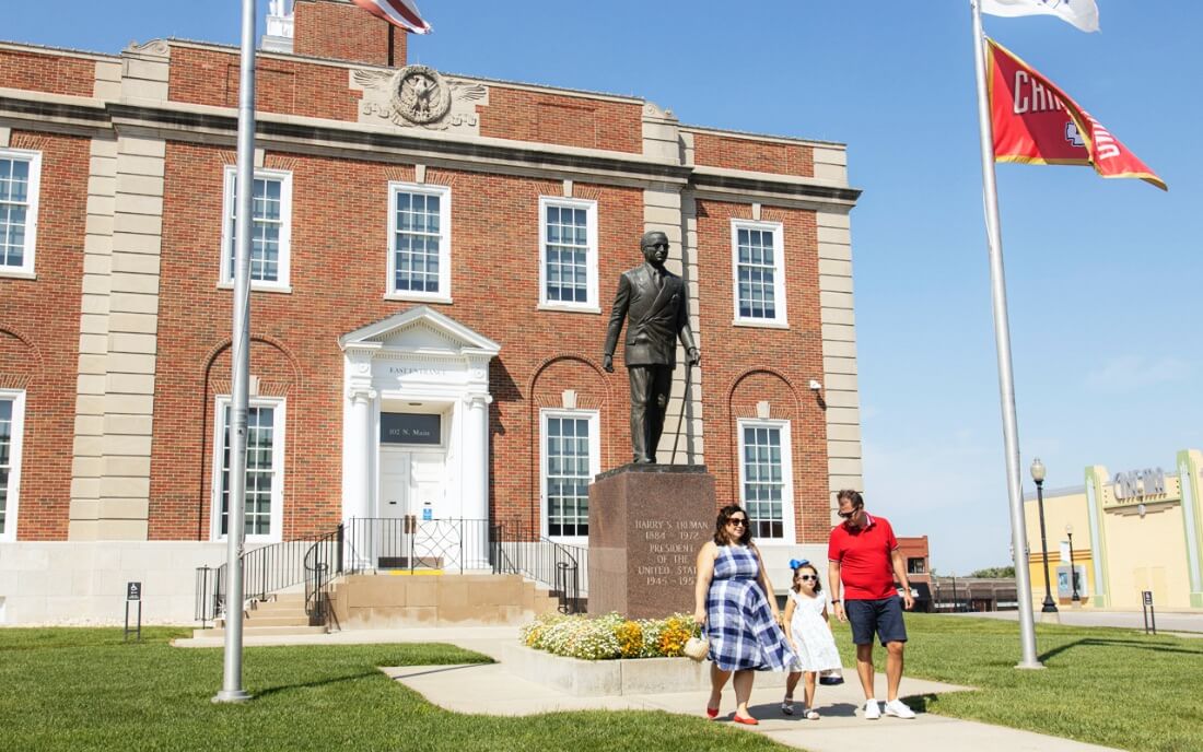 Influencer Jen Cowan and her family in front of the Harry S. Truman statue on the Historic Independence Square in Independence, MO
