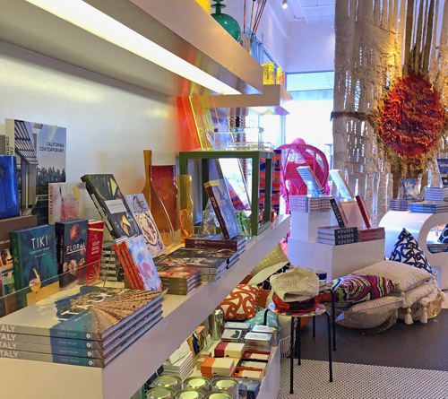 Interior of Trina Turk shop in Palm Springs, California’s Uptown Design District showing shelves of colorful books, candles, pillows, and home accessories