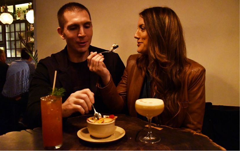 A couple enjoys their cocktails at Whisper Sister while sharing a delicious dessert