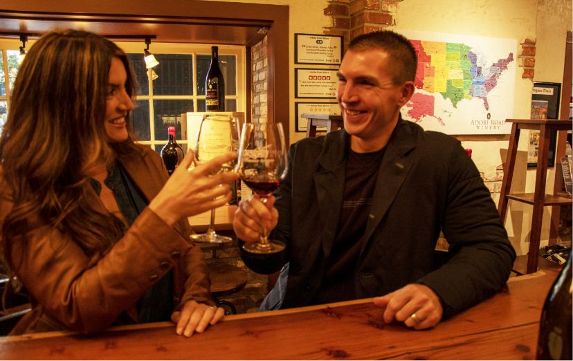 A couple raises their wine glasses in a toast at Adobe Road Winery
