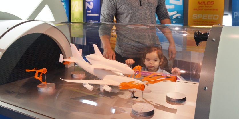 A little girl looks at a model rocket display in Space Center Houston in Bay Area Houston