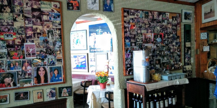 A wall filled with photos of local astronauts at Frenchie’s Italian Restaurant in Bay Area Houston