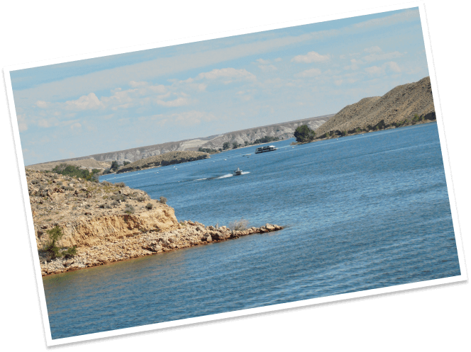 Boats ride across the placid waters of the Boysin Reservoir near Shoshoni, Wyoming.