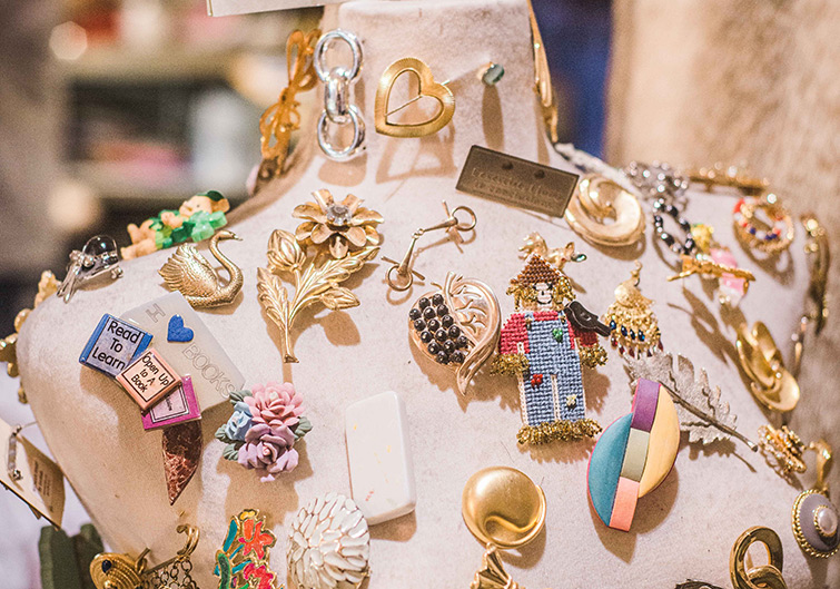 Dozens of decorative pins and broches decorate and cloth-covered mannequin body inside a boutique in Charleston, West Virginia.