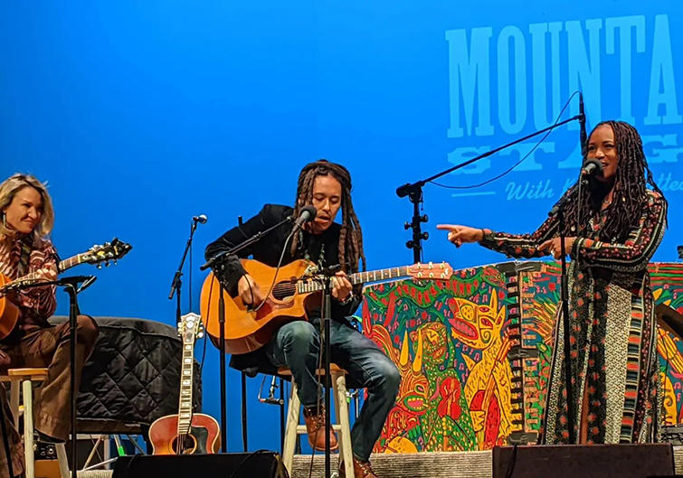 Three musicians play guitar and sing on the stage of Moutain Stage with Kathy Mattea in Charleston, West Virginia. 