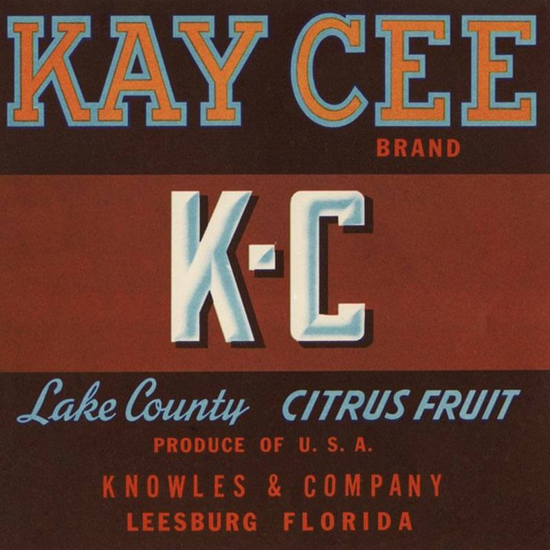 An illustrated Kay Cee brand citrus label is black with a red box holding a white K-C.