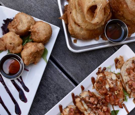 Onion rings, bruschetta and crab beignets, and plated appetizers at Civil Kitchen in Springfield, Missouri