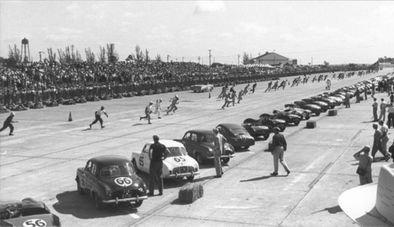 A black and white photos shows drivers running across the starting line to their racecars to begin the race at Sebring International Raceway in Sebring, Florida.