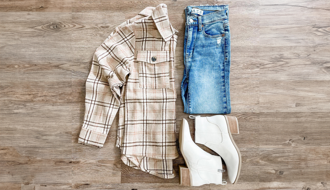 A beige flannel shirt, distressed jeans and white ankle boots are on display at Tassel & Thread in Avon Park, Florida.  