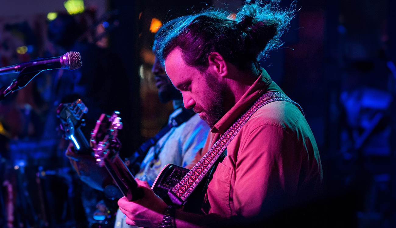 Musician Ethan Hanson looks down at his guitar while he plays at Your Pie Pizza in Lumberton, North Carolina.